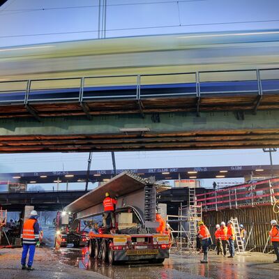 Schwerlasttransporter liefert großen Stahlträger an einer Brückenbaustelle an.