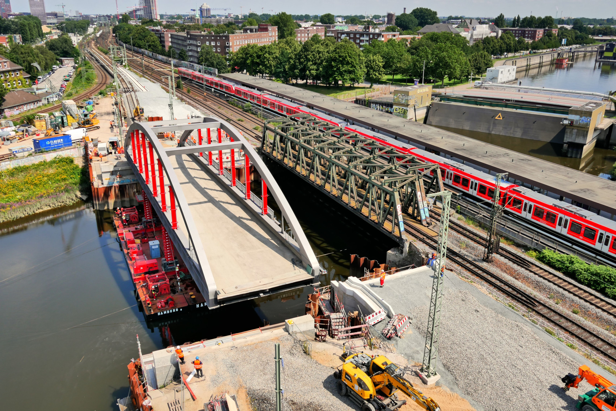 Luftbild der Stabbogenbrücke 1, die mit einem Ponton an die neue Position geschwommen wird.