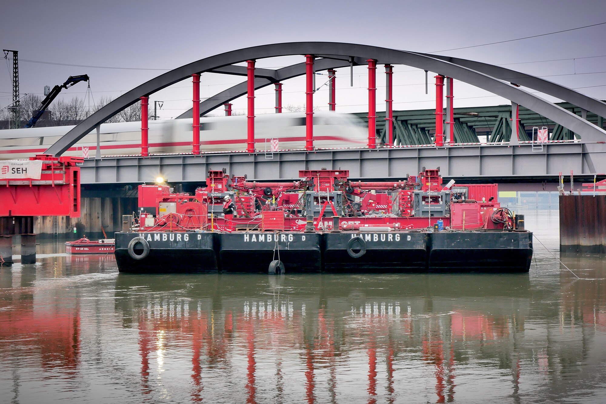 Schwimmende Arbeitsplattform mit Hubvorrichtung vor Eisenbahnbrücke Zollkanal.