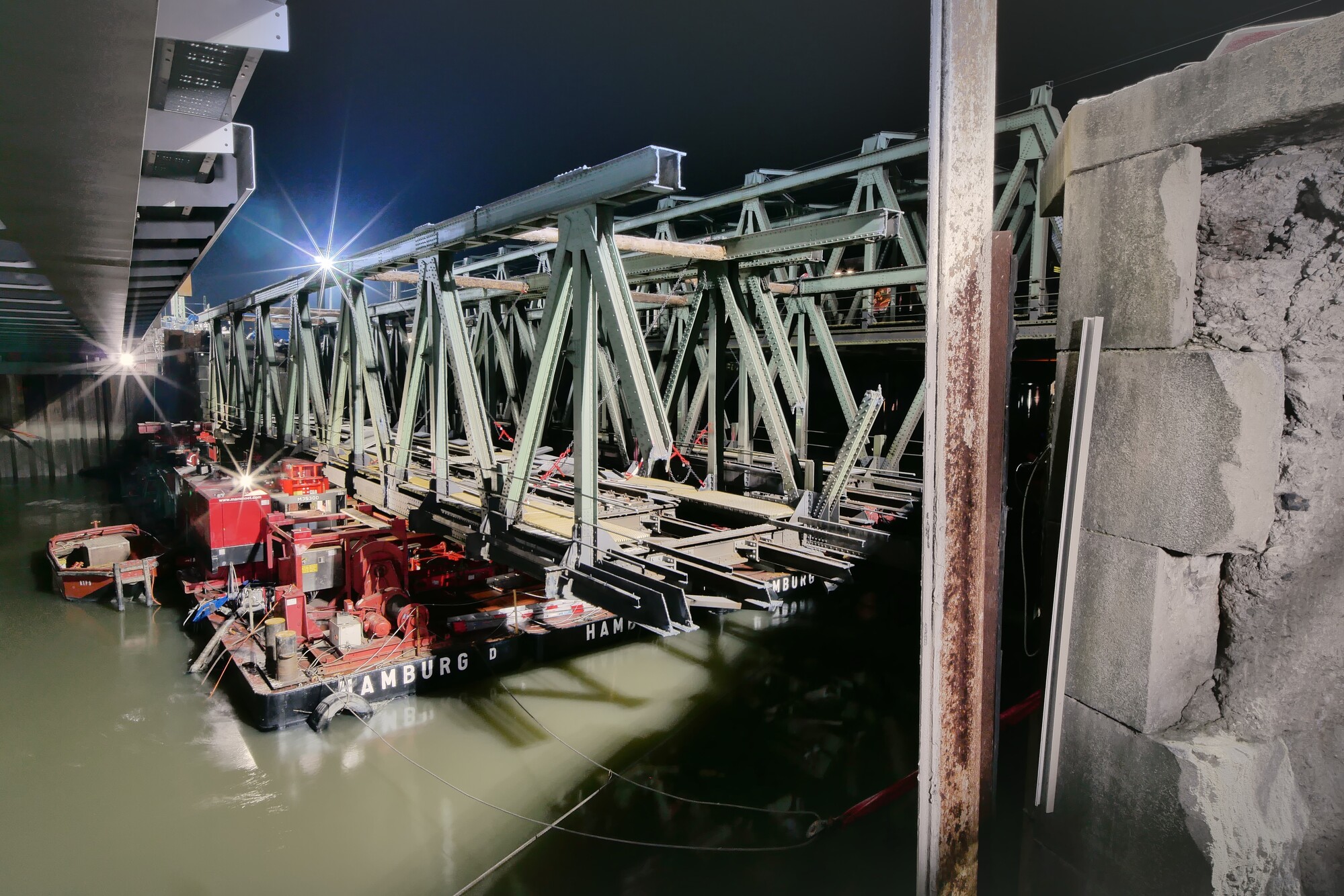 Eisenbahnbrücke wird von schwimmender Plattform aus mit Hubvorrichtung abgesenkt.