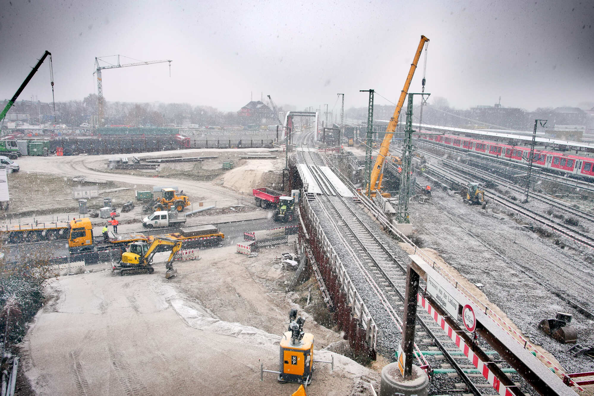 Ein Kran hebt den Bestandsüberbau der Eisenbahnbrücke Harburger Chaussee aus.